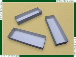 Boîte en carton brut gris, conception artisanale originale avec couvercle abattant et rainure-charnière tracée dans le carton. Solidité des coins assurée par agrafage, fabrication française selon méthode traditionnelle